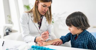 Doctor doing prick tests on male child to test for allergies