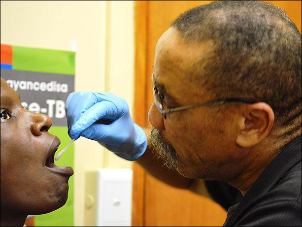 Medical staffer collects patient's swab sample for TB testing