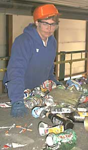 A worker comes across needles on a trash conveyor belt