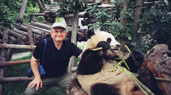 Dr. Ness posing with a Panda in China.