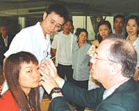 Bradley K. Farris, MD, examining a Chinese patient with residents