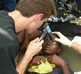 Justin Townsend, MD, from the Bascom Palmer Haiti Relief team, examines a boy with traumatic optic neuropathy.