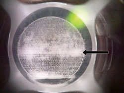 An increase in opaque bubble layer (arrow) is visible at the junction where the second raster pass went through the border of the interrupted first raster pass.