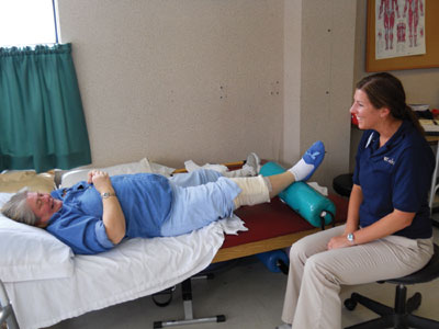 A physical therapist assistant at The Laurels coaches Operation Joint Implant patient Rosie Pennington after her total knee replacement.