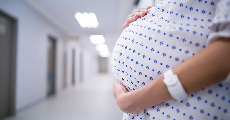 Pregnant woman standing in hospital corridor