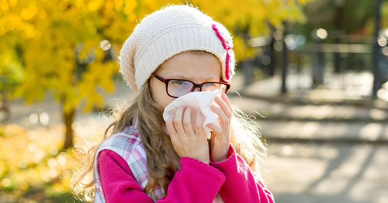 little girl blowing her nose