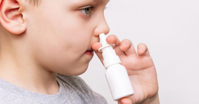 Boy using a nasal spray