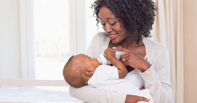 Woman giving a baby a bottle