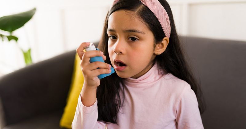 girl using asthma inhaler