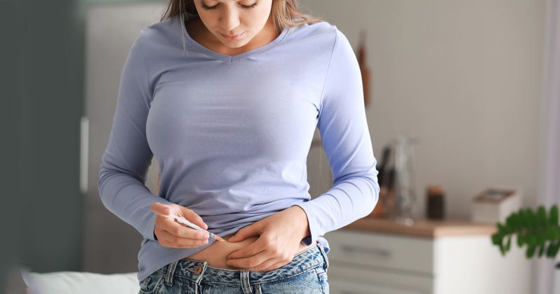 woman giving herself insulin