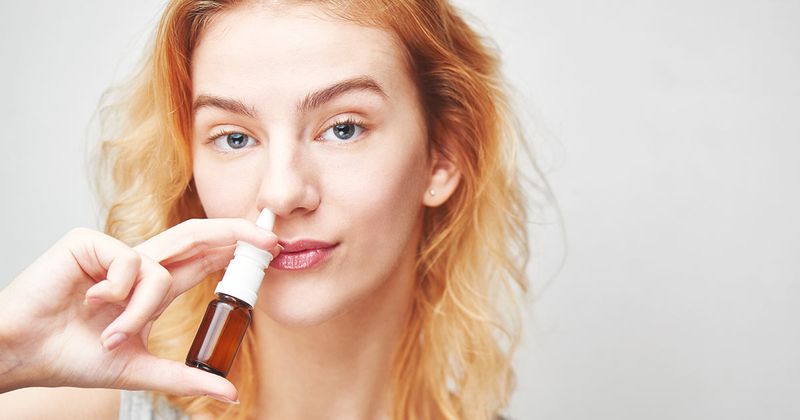 woman using nasal spray