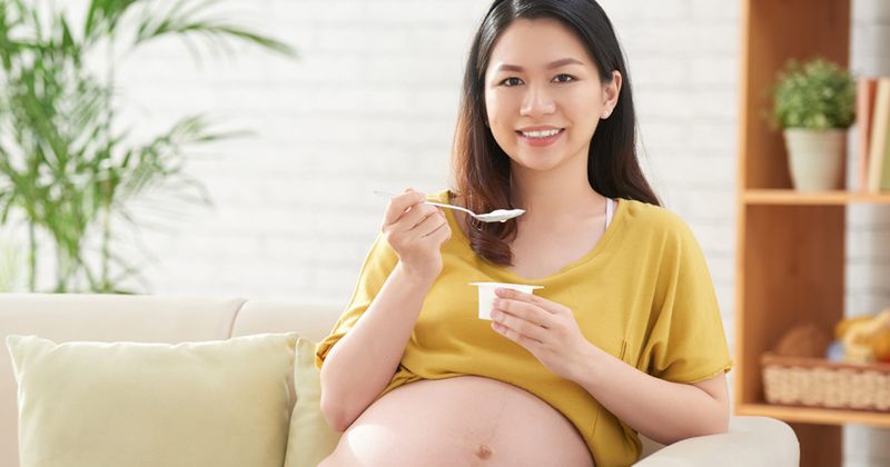 pregnant woman eating yogurt