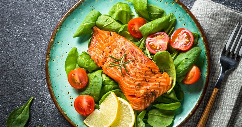 Baked salmon fish fillet with fresh salad.