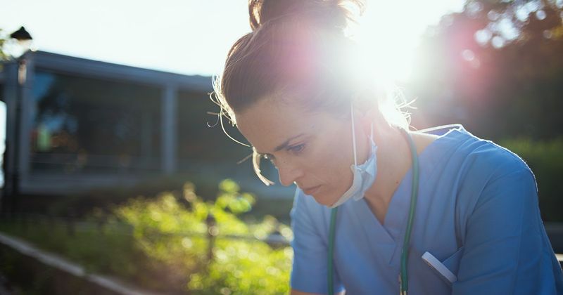 Female health care professional sittinng outside