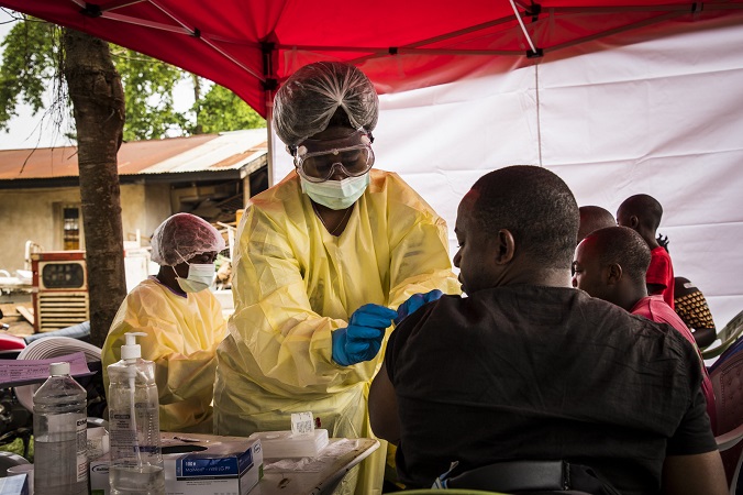 Photo of a health care worker adminstiering the Ebola vaccine