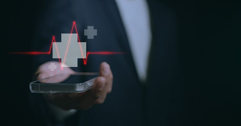 Picture of a hand holding a cell phone with a red cross graphic overlaid