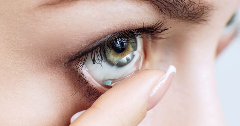 woman inserting contact lens