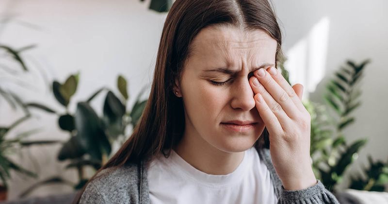 woman rubbing eye