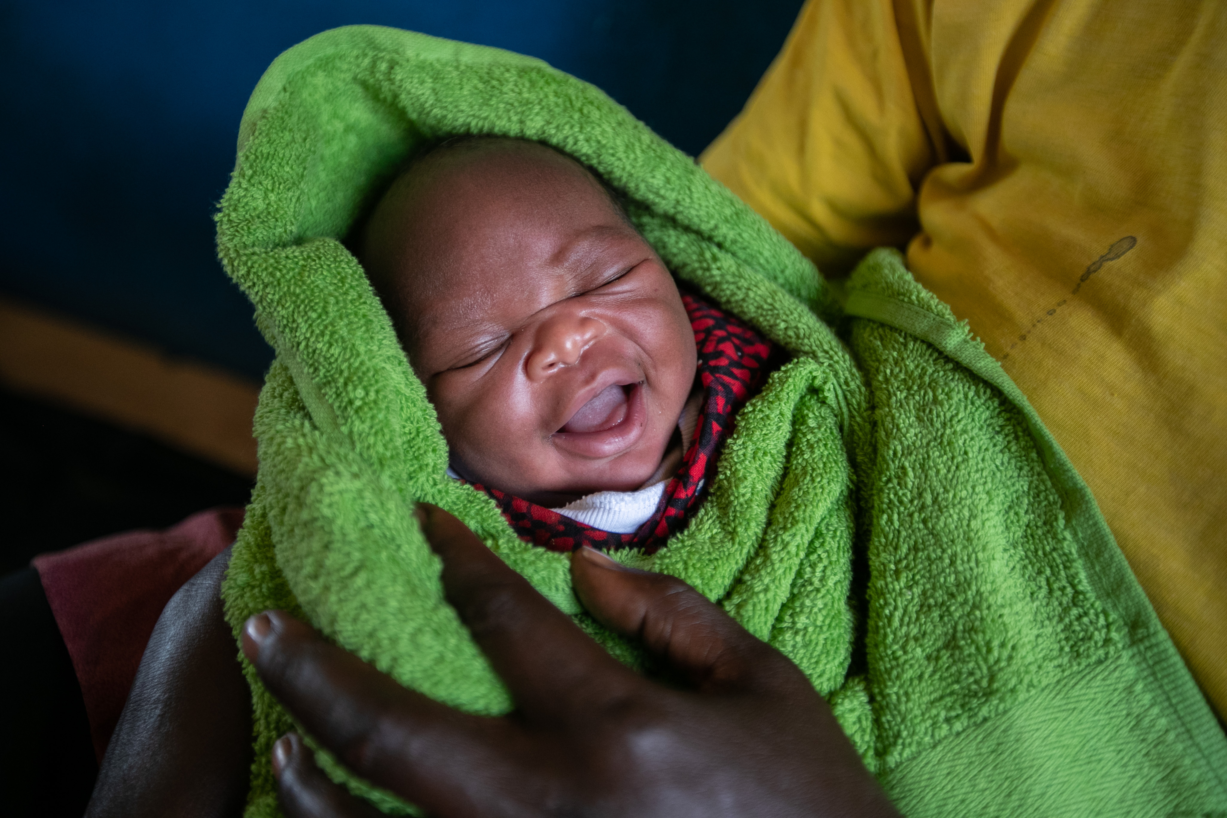 A photo of a baby wrapped in a green blanket