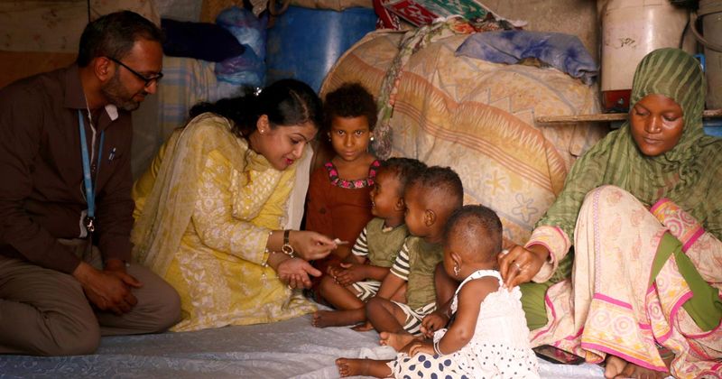 Imran Nisar, MB, BS, far left, and Fyezah Jehan, MB, BS, left, speak with study participants in Karachi, Pakistan. CREDIT: Farheen Ayub