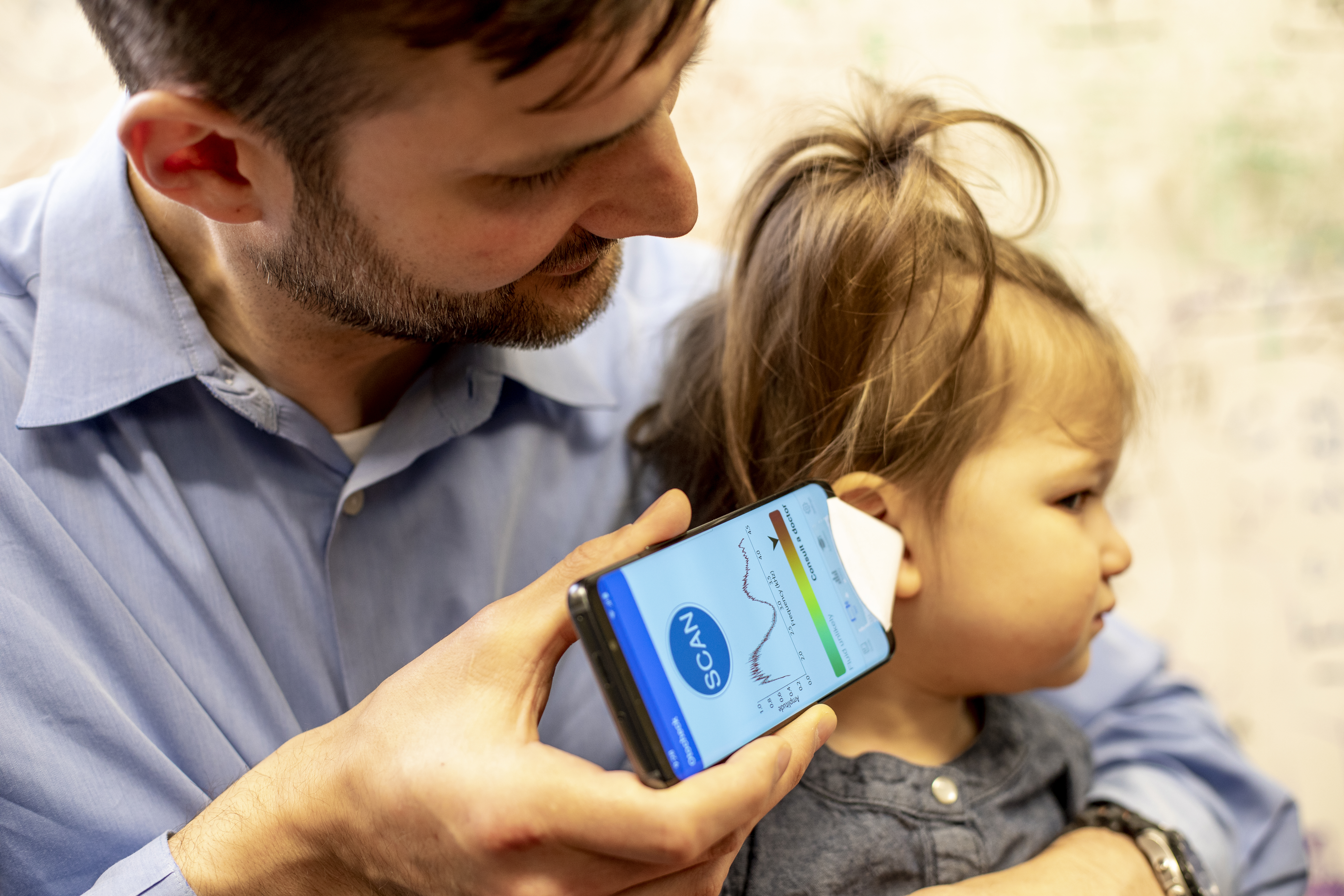 Randall Bly checks patient's ear using smartphone app for ear infections