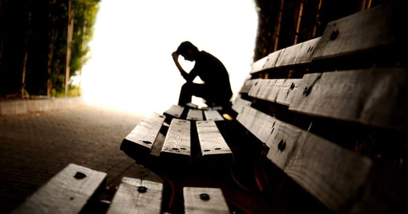 man with depression sitting on bench 