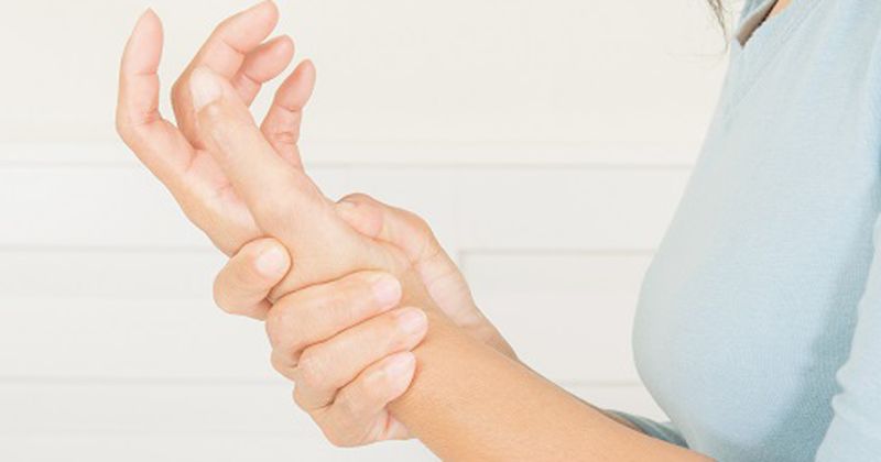 woman holding wrist in pain