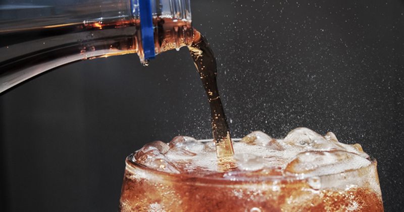 a soda being poured in a glass