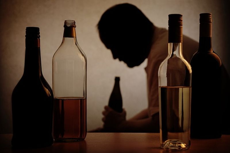 Alcohol bottles and person holding one of them