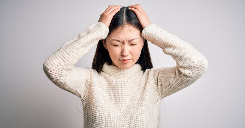 Young Asian woman experiencing headache