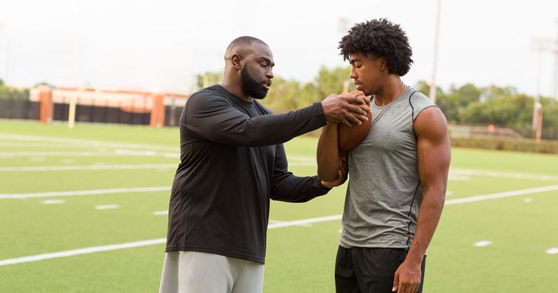 Black man coaching Black athlete