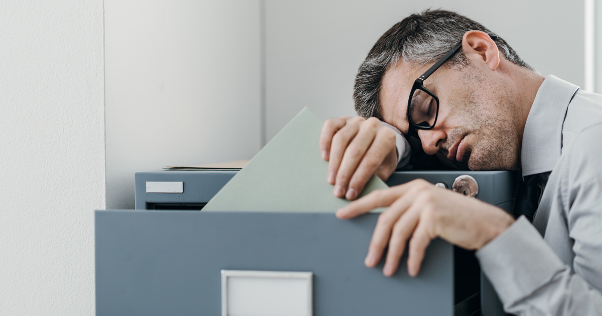 Man asleep at filing cabinet