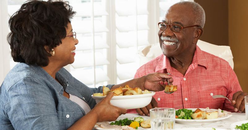 Older Black couple eating vegetables