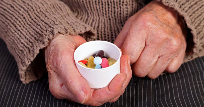 Older woman holding pills