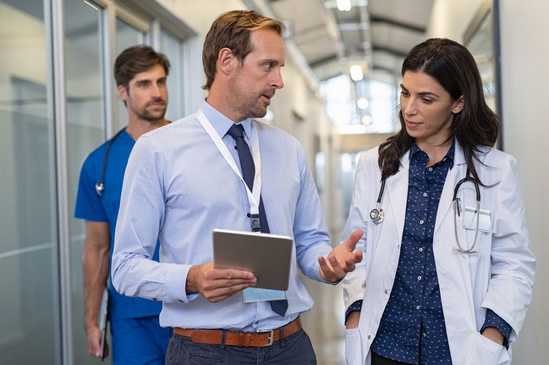 Stock photo of male and female physicians discussing information. Source: Adobe Stock photo.