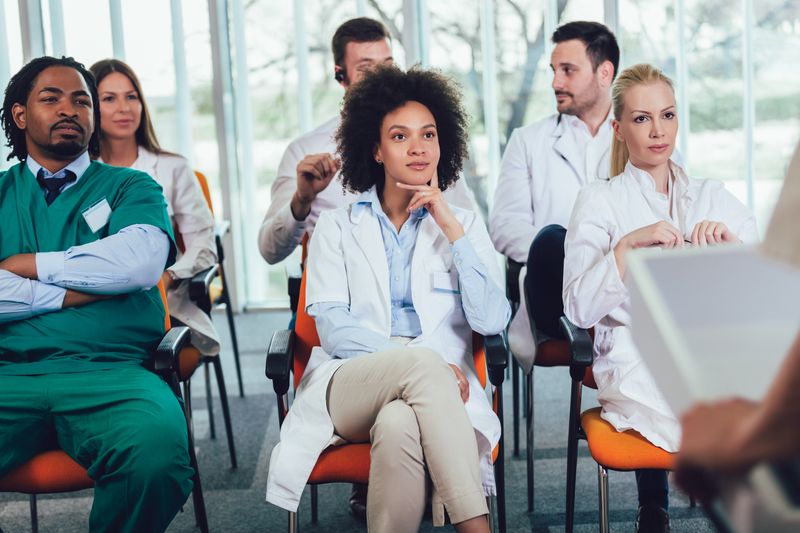 Image of a physician audience listening to a speaker. Source: Adobe Stock photo.