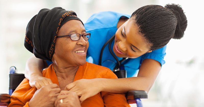 Photo of woman in wheelchair with nurse