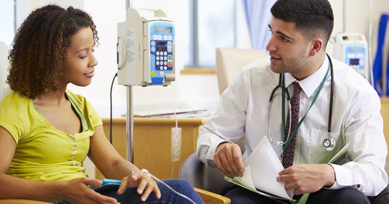 Photo of woman receiving chemotherapy with doctor