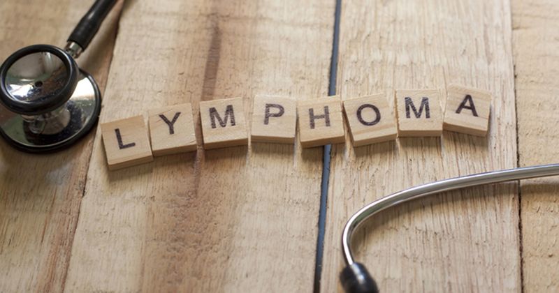 Scrabble tiles on a table spell out 'lymphoma.'