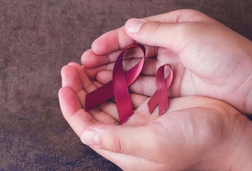 Hands holding burgundy ribbons.