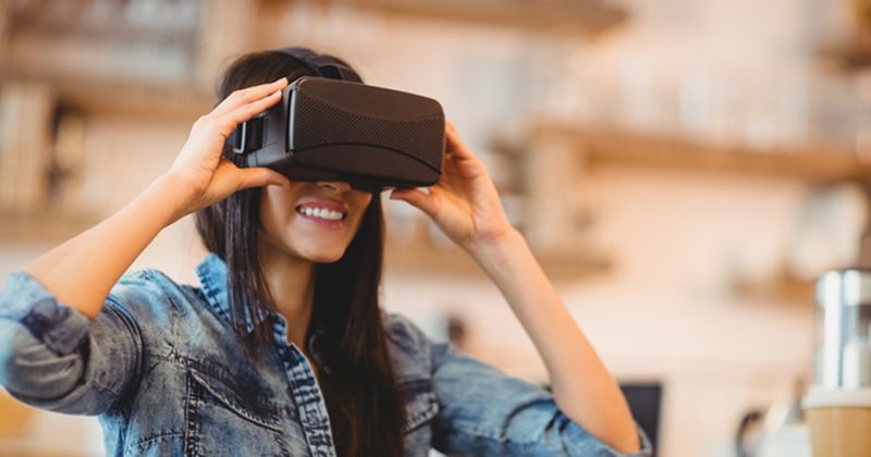 Photo of woman using virtual reality goggles