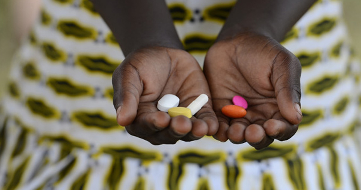 Image of child holding pills. 