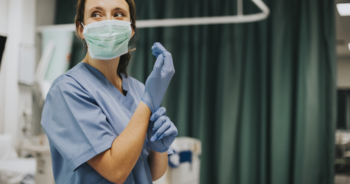 Photo of a HCW putting on gloves