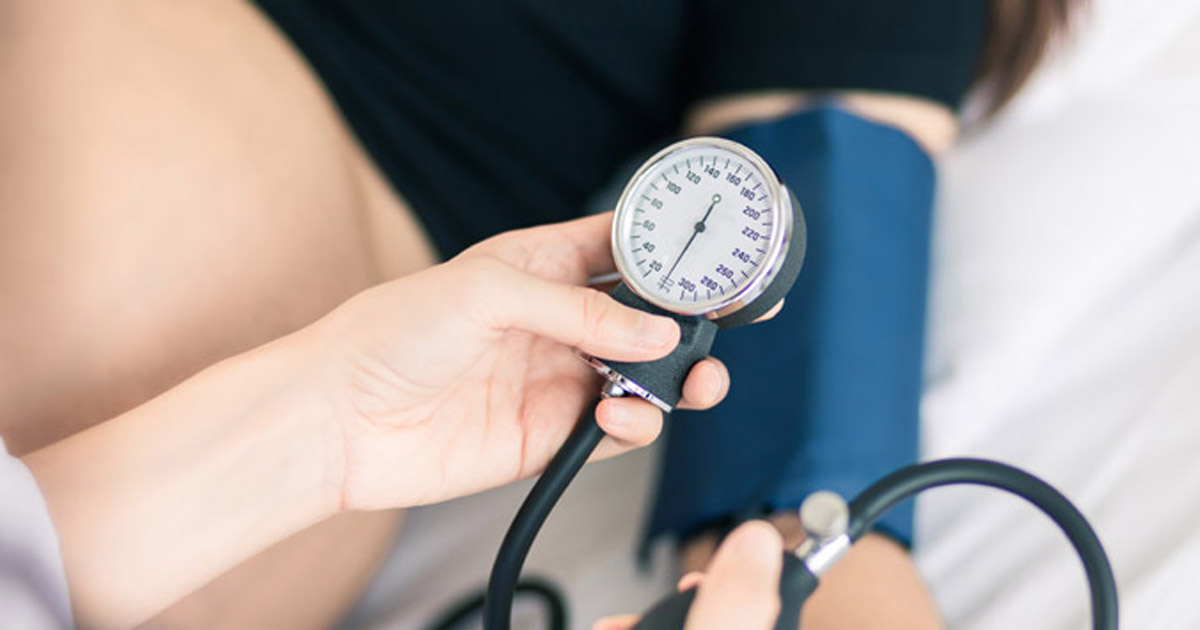 doctor taking pregnant woman's blood pressure