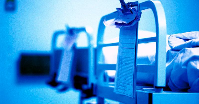 Nurse making empty hospital bed