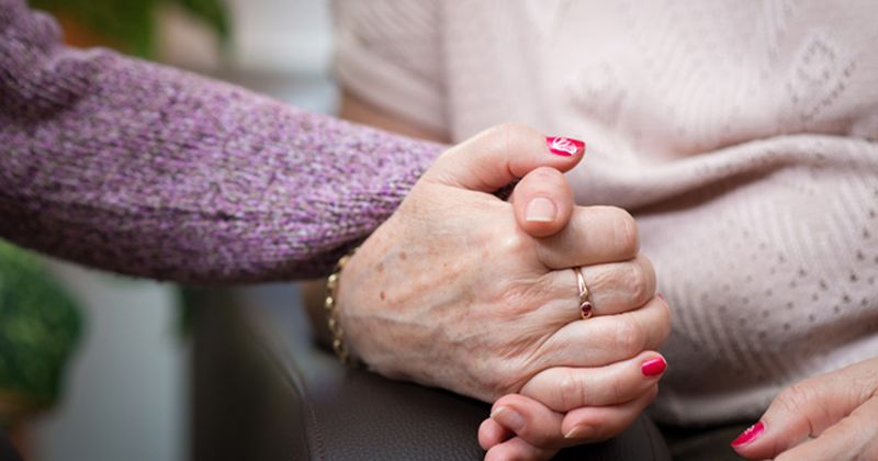 Older woman's hand being held