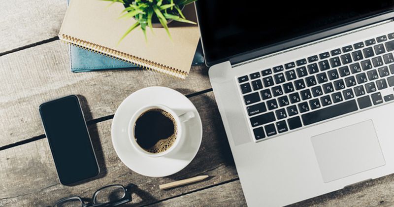 Desk with laptop and cup of coffee