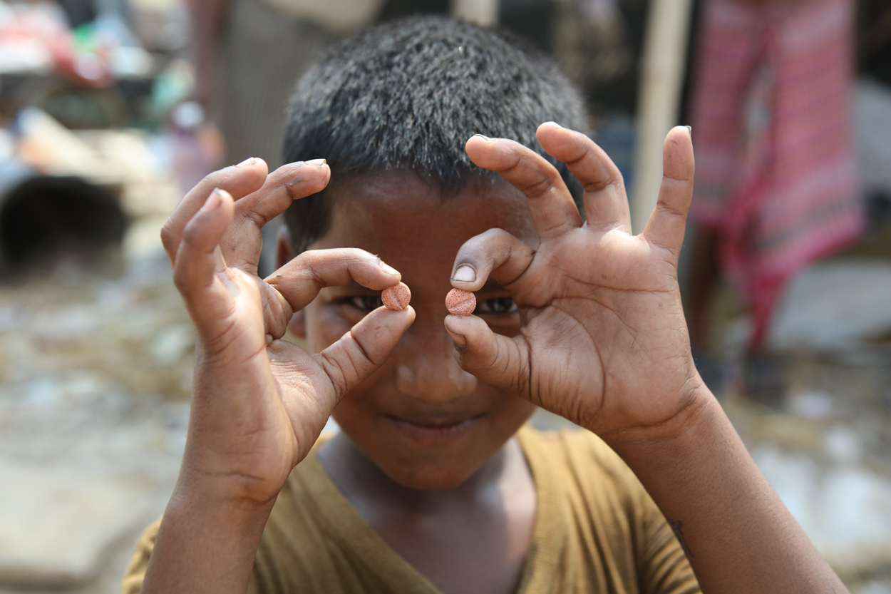 A boy in Delhi holds up improved TB medicines for children