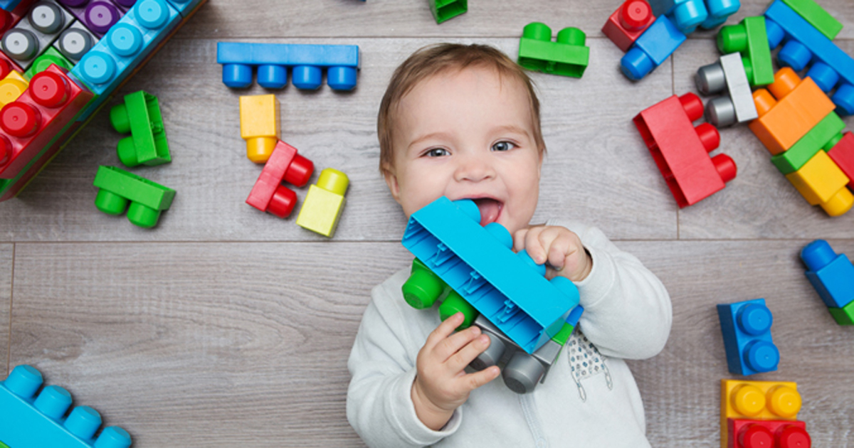 Baby with toy block in mouth