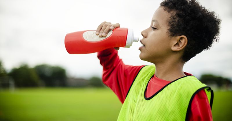 Child athlete drinking from bottle_Adobe